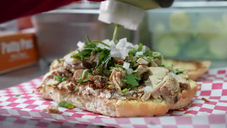 Squirting-guacamole-avocado-salsa-sauce-on-a-cheesesteak-sub---food-truck-series