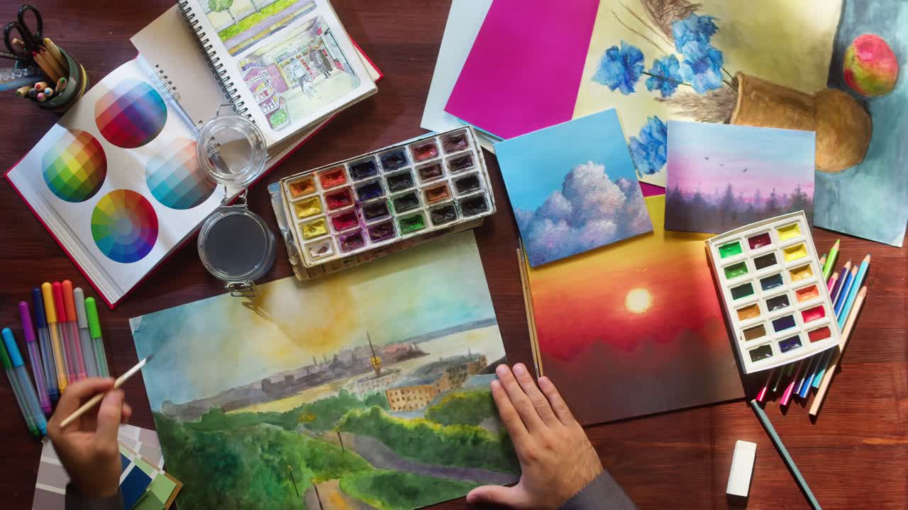 Artist's Hands Painting Watercolor Landscape on Desk