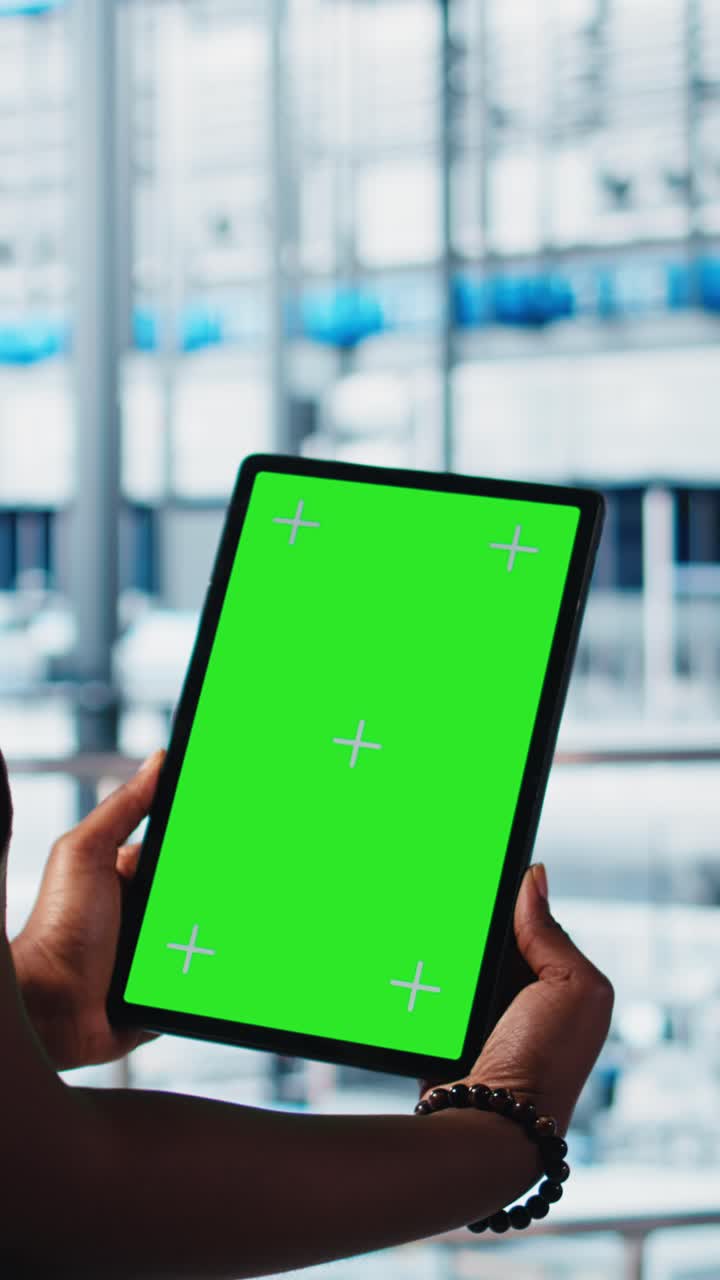 Vertical video Smart factory specialist manages robotic arms using mockup tablet, close up
