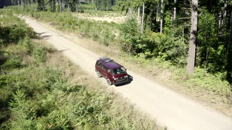 VW-Van-vintage-van-driving-through-forest-aerial-view-4k-drone