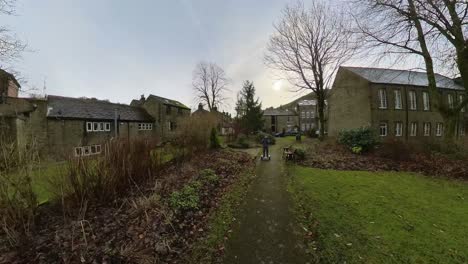 young boy riding a electric segway, scooter, hoverboard in a rural village churchyard enviroment