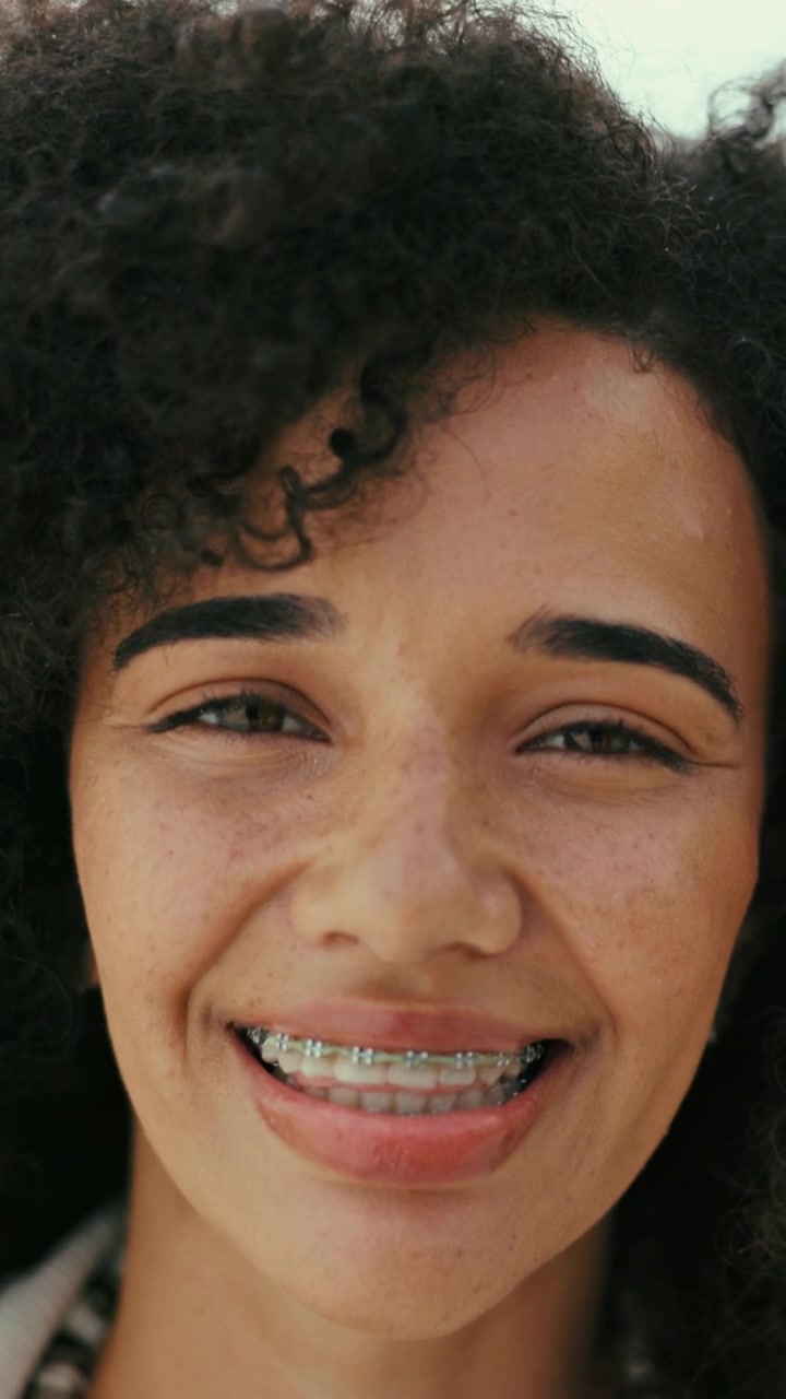 Ritratto in primo piano di una giovane donna sorridente con capelli ricci
