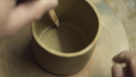 a potter makes a clay teapot with his own hands