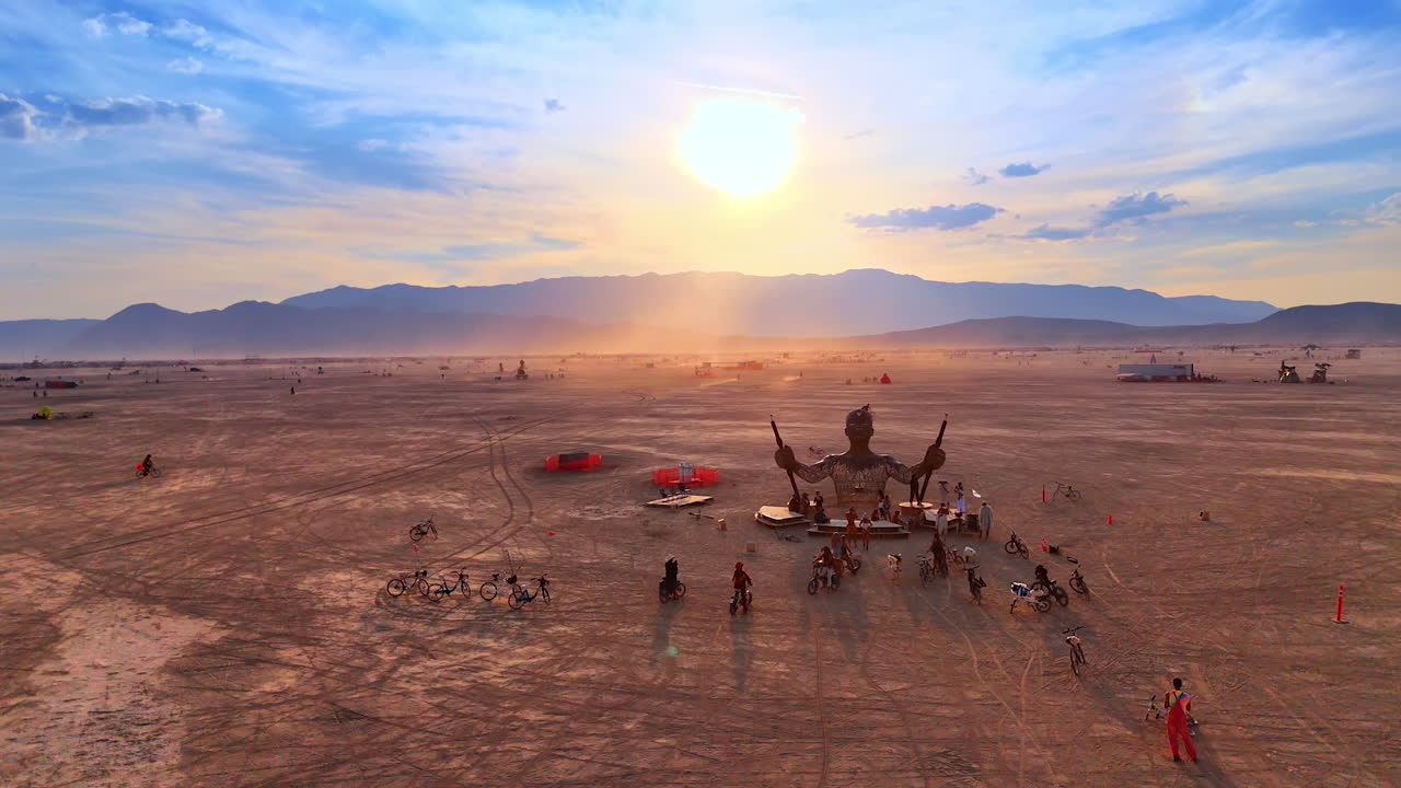 Nevada, USA, 22 August 2025: Sunset over Burning Man desert with installation. Art installation in the desert with the sun setting behind mountains during Burning Man festival