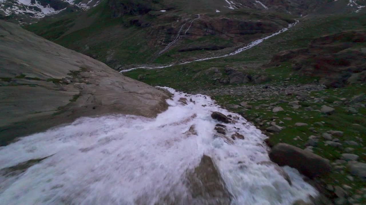 vuelo de un avión no tripulado sobre un río que fluye en el glaciar fellaria, valmalenco, alpes italianas