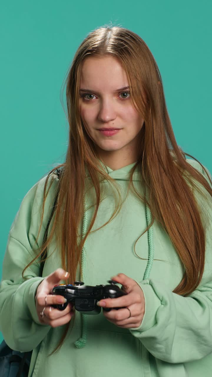 Vertical video Young gamer girl holding controller, focused on finishing game