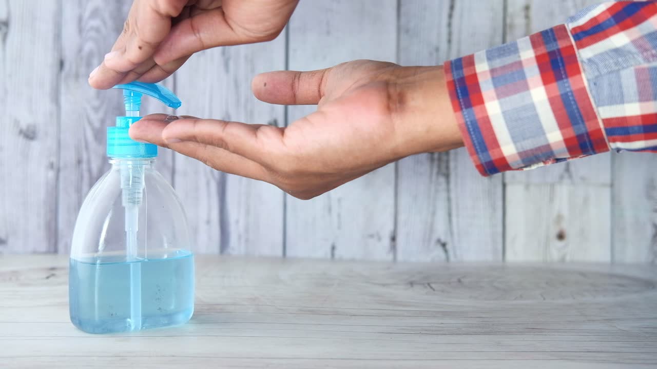persona que aplica desinfectante para las manos