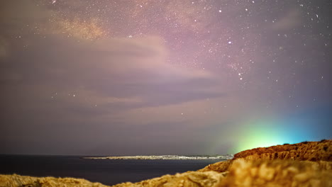 el lapso de tiempo de la vía láctea con la isla en el fondo con la formación de nubes y coches conduciendo