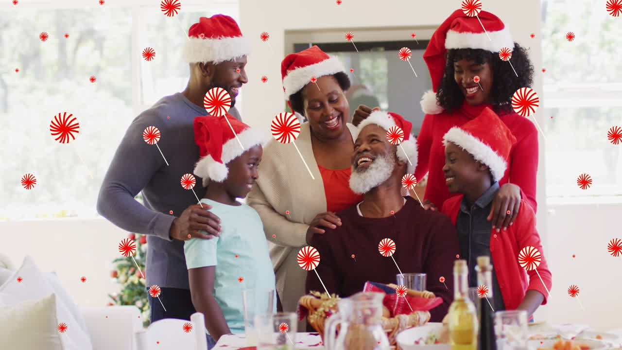 Animação de doces caindo sobre uma família afro-americana feliz durante a ceia de Natal