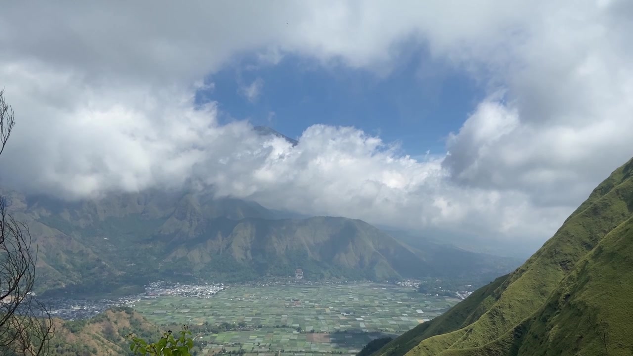 Pemandangan Panorama Lembah Hijau Subur dan Pegunungan di Bawah Langit Berawan