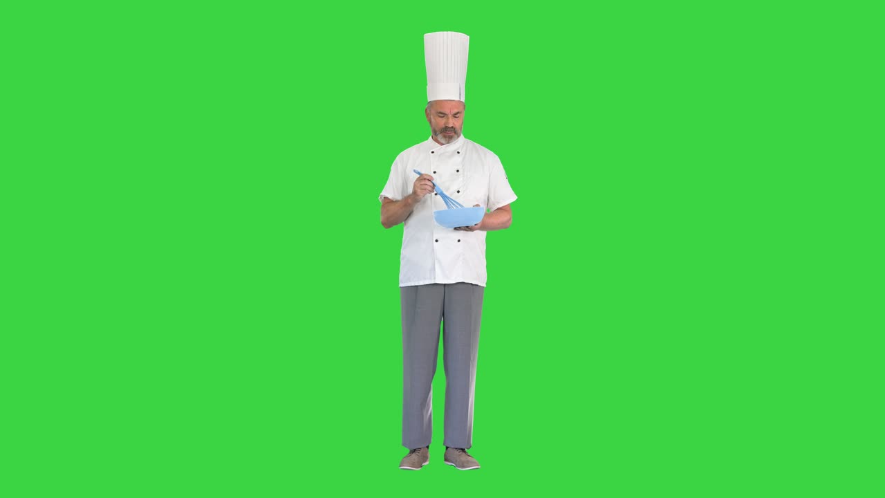 Cook chef with a bowl and whip preparing food on a Green Screen, Chroma Key