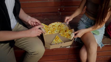 pareja disfrutando de una pizza juntos