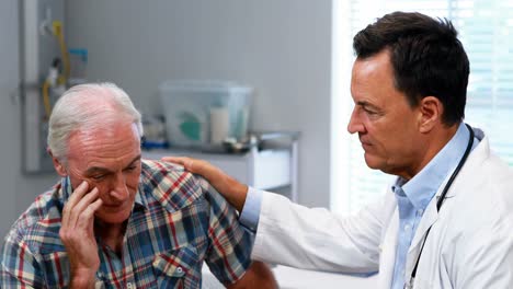 el médico consuela al hombre mayor.