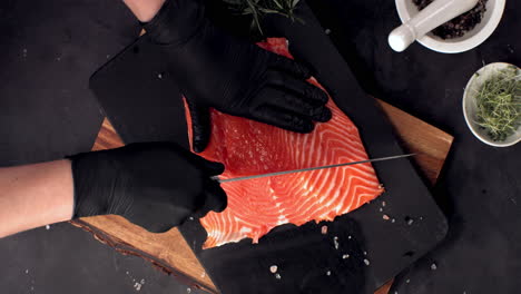 super slow motion overhead view of cutting fresh uncooked salmon fillet lying on table. shot with high speed camera, 420 fps