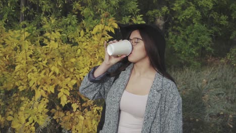 mujer disfrutando de café en el parque de otoño
