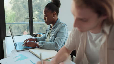 two people working on laptops at a table