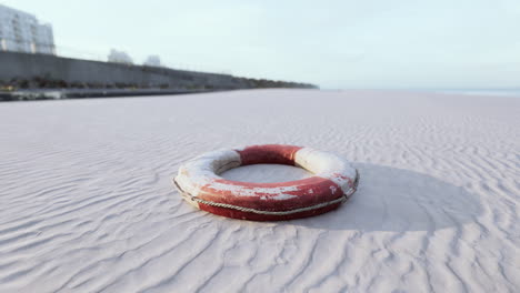 red and white life preserver on a sandy beach