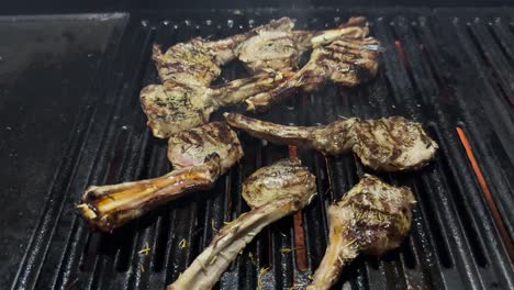 chuletas de cordero chisporroteando en una parrilla de barbacoa