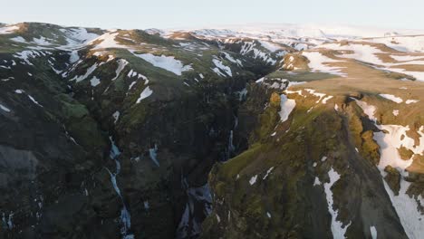 vista aérea del paisaje sobre un cañón de montaña con nieve derretida y un río que fluye dentro