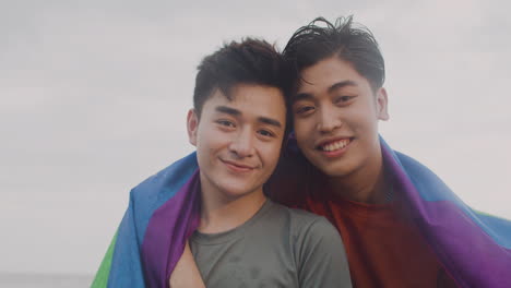 una pareja con una bandera arco iris.