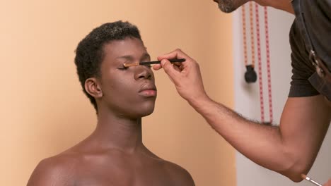 crop visagiste filling in eyebrows of black transgender