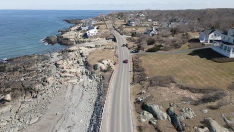 aerial drone footage of coastal community on the atlantic in cohasset, ma, drone follows the road next to coastline