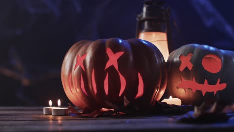 video of halloween carved pumpkins, candles and smoke with copy space on blue background