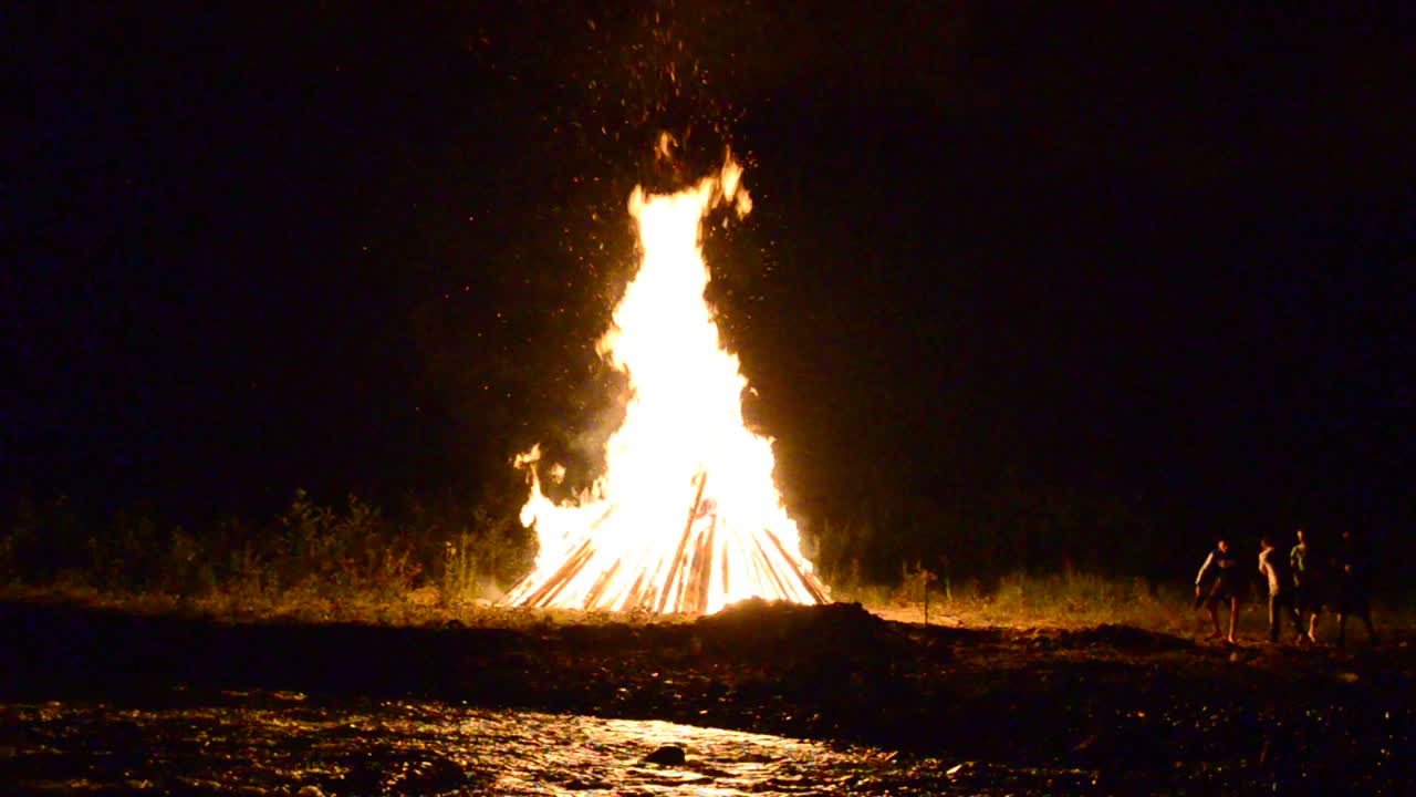 Gebirgsfluss und Feuer. Feuer zum Iwan-Kupala-Fest, Juli, Sommer, Ukraine.
