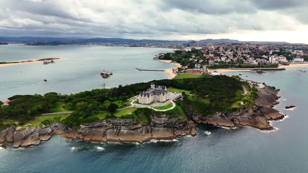 Historical Palace located at the coast of Spain, surrounded by trees (drone footage)