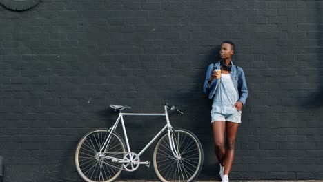 Woman-having-coffee-while-leaning-against-wall-4k