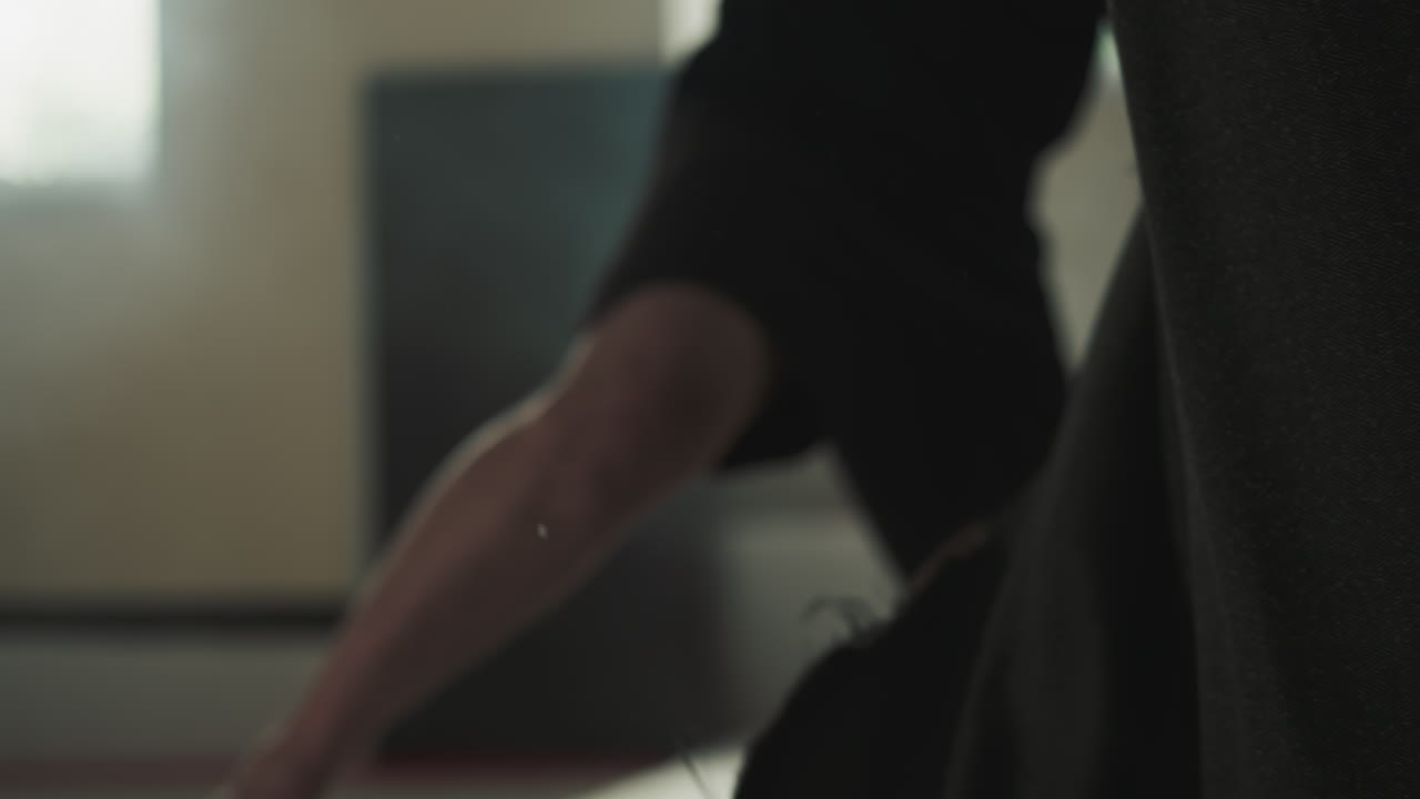 권투 장갑을 입은 남자가 다리를 고 권투를 위해 스포츠 클럽에 있는 권투 가방에 힘을 다해 는다.