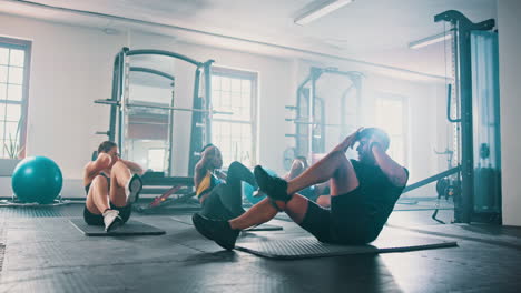 group workout session: sit-ups and exercises in a fitness gym
