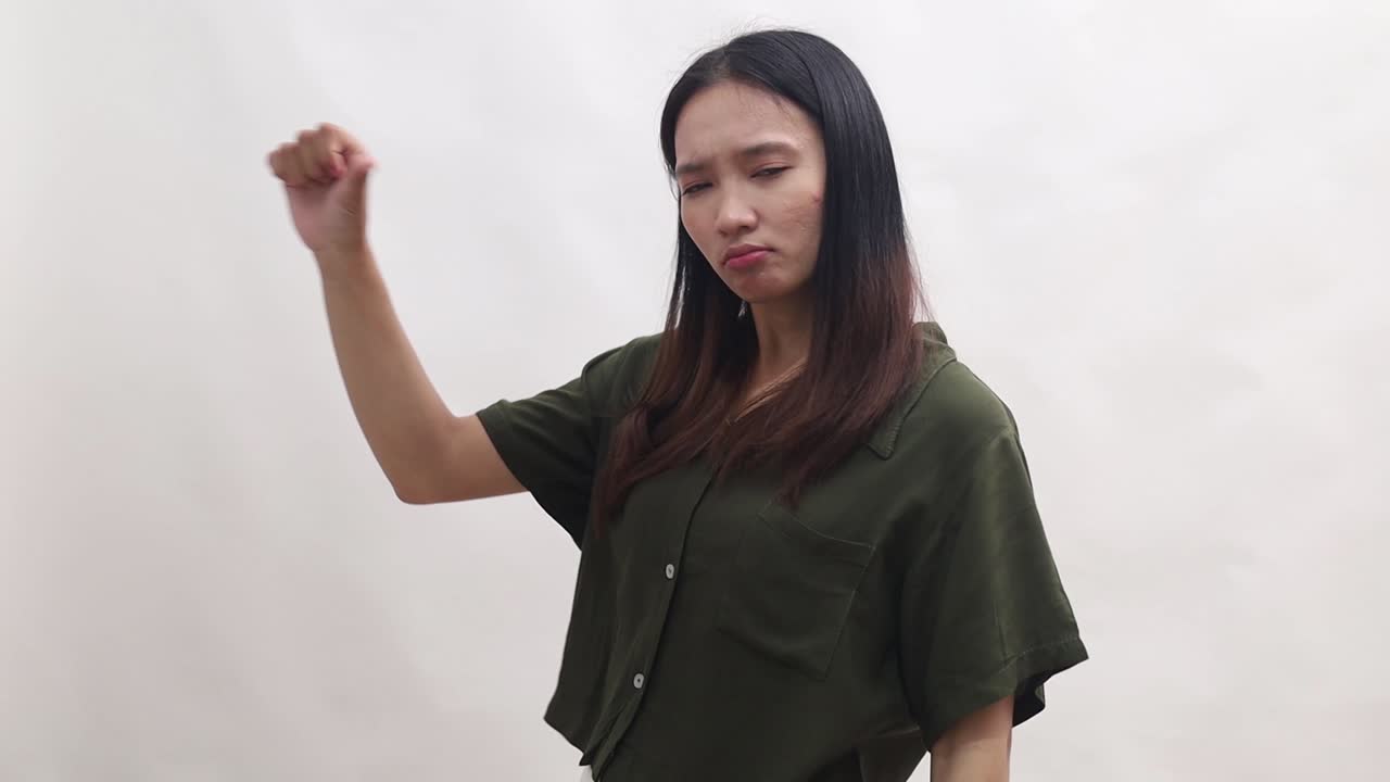 Young Asian woman is denying and disagreeing with something aside. Isolated on white background