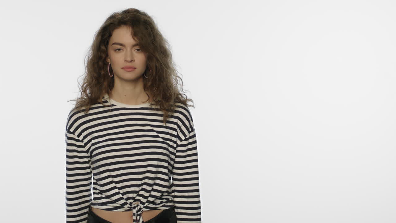 mujer joven anunciando un producto con un gesto de la mano sobre un fondo blanco