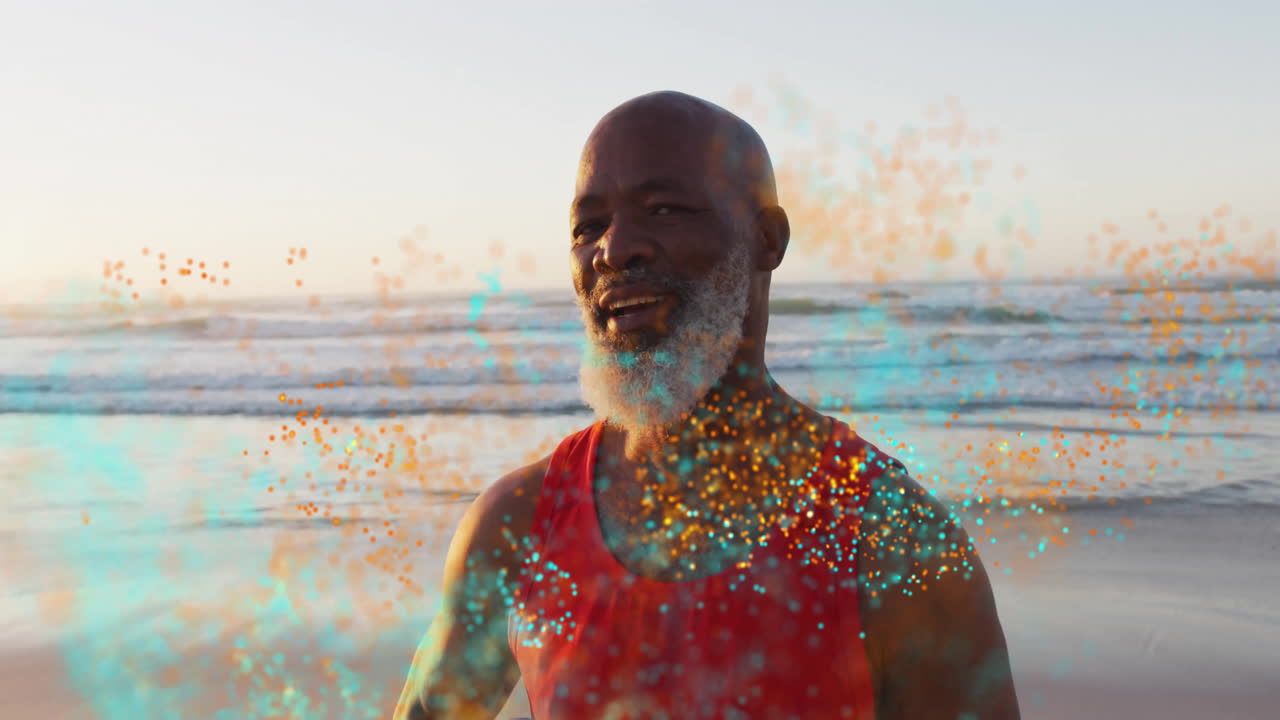 By ocean, man in red tank top smiling with colorful animation particles