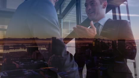 composición digital de dos hombres de negocios caucásicos que se dan la mano en la oficina contra el paisaje urbano nocturno