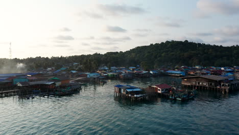 imágenes aéreas de drones volando alrededor de una aldea flotante en una isla en camboya