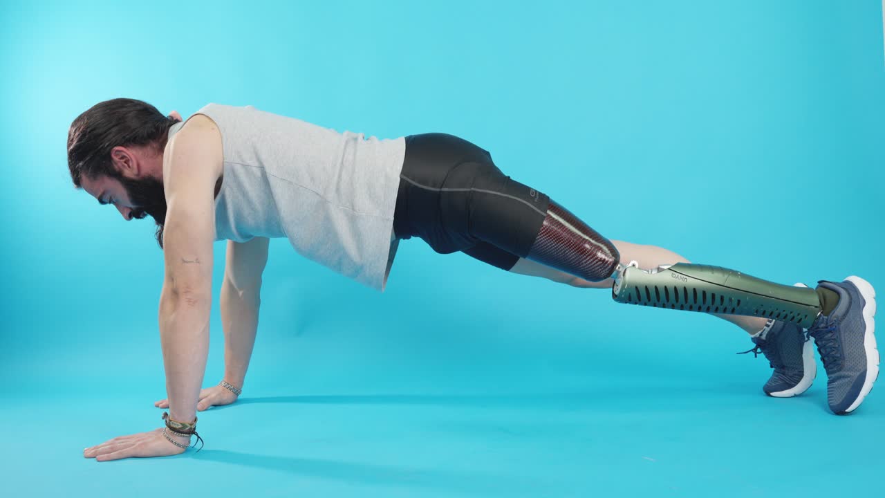 Man with prosthetic leg performing a push-up on a blue background