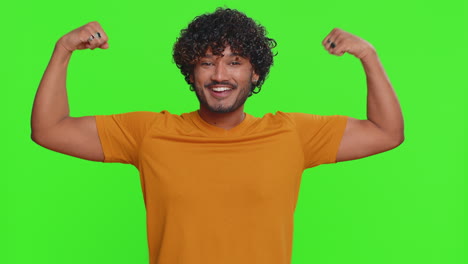 fit sporty indian young man showing biceps and looking confident feeling power strength success win