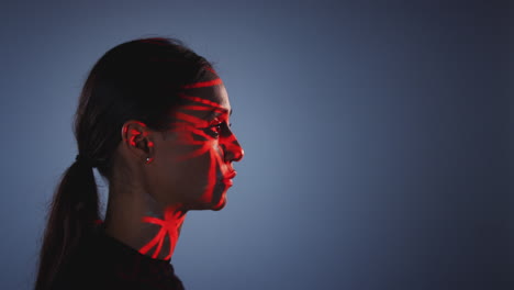 Facial-Recognition-Technology-Concept-As-Woman-Has-Red-Grid-Projected-Onto-Face-In-Studio