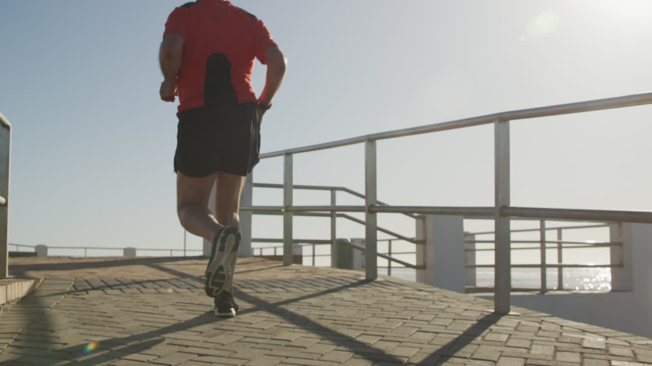 hombre mayor corriendo en el paseo marítimo