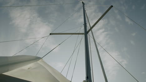 sailboat mast and rigging against cloudy sky