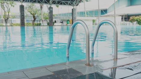 closeup shot of grab bars ladder in the swimming pool at morning day