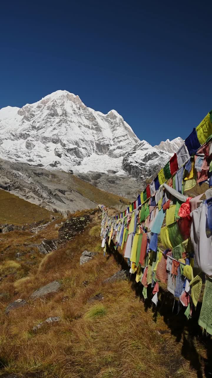 Prayer flags in the Himalayas with majestic snow-capped mountains in the background