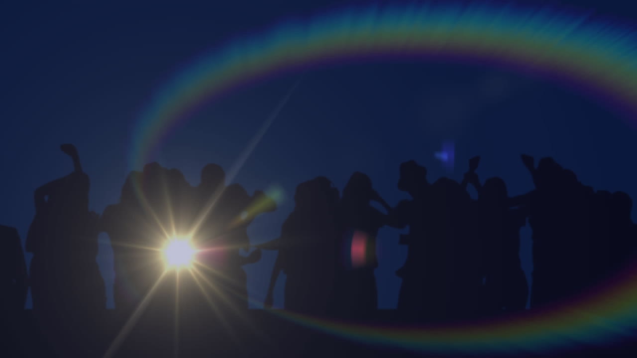 무지개 헤로와 함께 스포트라이트의 애니메이션이 춤추는 사람들의 무리의 실루 ⁇ 과 함께 움직입니다.