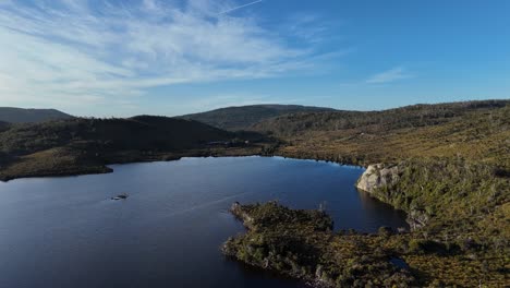 aerial view of a serene lake surrounded by mountains and vegetation