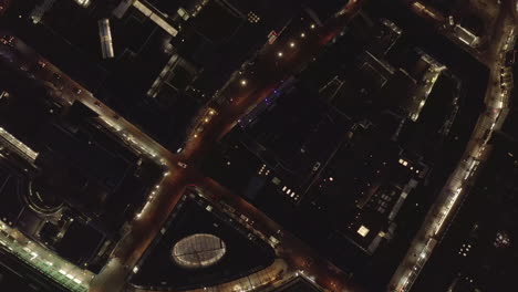 AERIAL:-Slow-Overhead-Shot-of-City-at-Night-with-Lights-and-Traffic,-Cologne,-Germany