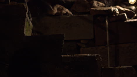 Closeup-shot-of-a-persons-legs-walking-up-stone-steps-on-at-nighttime,-wearing-boots