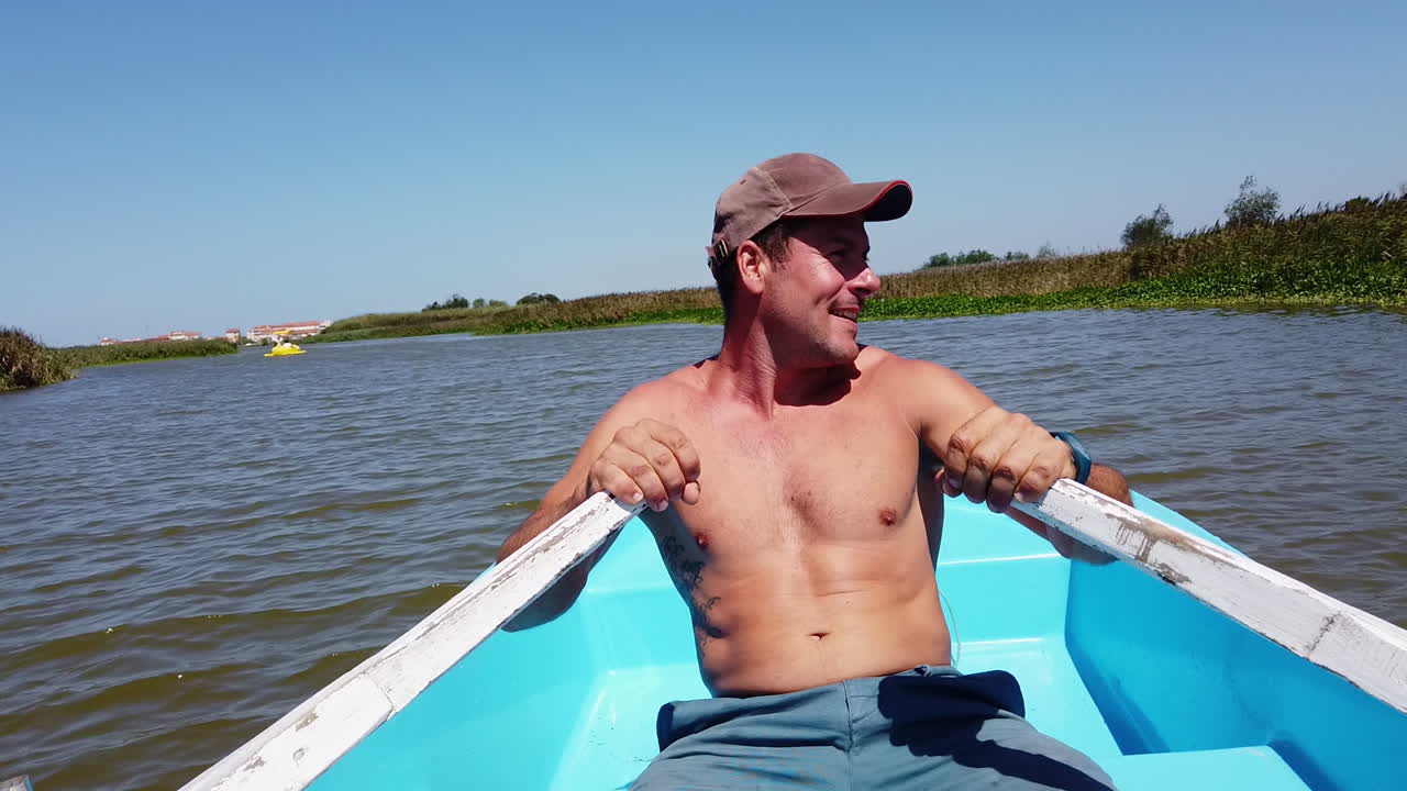Man rows in small boat off shore in Portugal, calm and serene waters