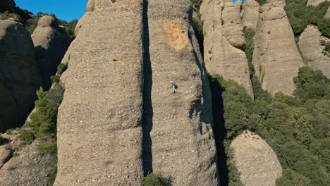 Seitliche-Bewegung-Eines-Bergsteigers,-Der-Eine-Der-Nadeln-Des-Berges-Montserrat-Erklimmt